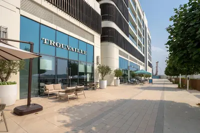 a large glass building with tables and chairs outside at Fully Furnished - 1 BR - Palm View with Beach Access in Dubai