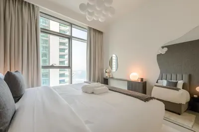 a bedroom with a white bed and a large window at Fully Furnished - 1 BR - Palm View with Beach Access in Dubai