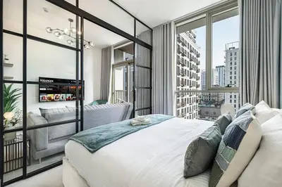 a bedroom with a large white bed and a large window at Beautiful 1 Bedroom Dubai Hills with Pool View in Dubai