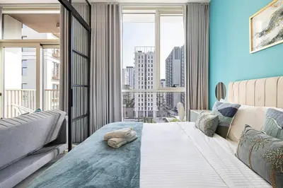 a bedroom with a bed and a large window at Beautiful 1 Bedroom Dubai Hills with Pool View in Dubai
