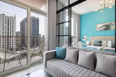 a living room with a couch and a balcony at Beautiful 1 Bedroom Dubai Hills with Pool View in Dubai