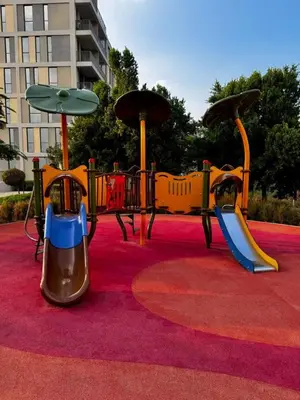 a playground with a slide on a red carpet at Modern 1-bedroom apartment in family-friendly residence with Swimming Pool, Gym & Free Parking. in Dubai