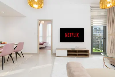 a living room with a tv on a wall at Modern 1-bedroom apartment in family-friendly residence with Swimming Pool, Gym & Free Parking. in Dubai