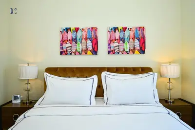 a bedroom with a bed with two pictures on the wall at Luxury Escapes - Budget 1BR Apt in Marina - Near Tram & Metro -Time Place Tower in Dubai