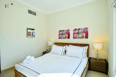a bedroom with a bed with white sheets and pillows at Luxury Escapes - Budget 1BR Apt in Marina - Near Tram & Metro -Time Place Tower in Dubai