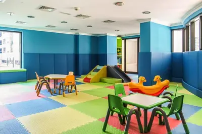 a childrens play room with tables and chairs and a slide at Luxury Escapes - Budget 1BR Apt in Marina - Near Tram & Metro -Time Place Tower in Dubai