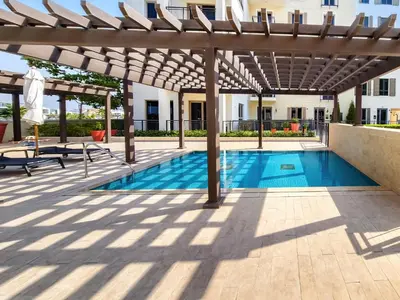a swimming pool with a wooden pergola and a swimming poolvisor at Sea View 3 BD apartment in La Mer near the beach in Dubai