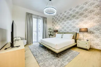 a bedroom with a bed and a flat screen tv at Sea View 3 BD apartment in La Mer near the beach in Dubai
