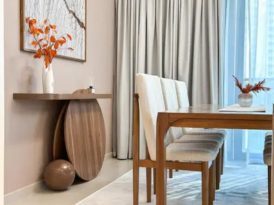 a dining room with a wooden table and a vase of flowers at Unique Burj Khalifa View 3BR Condo On Top Floor in Dubai