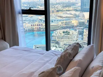a bed in a room with a large window at Unique Burj Khalifa View 3BR Condo On Top Floor in Dubai