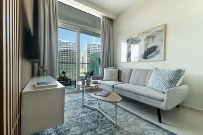a living room with a couch and a large window at Frank Porter - Reva Residence in Dubai