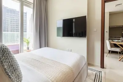 a bedroom with a bed with a television on the wall at Frank Porter - Reva Residence in Dubai