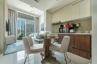 a kitchen and living room with a table and chairs at Frank Porter - Reva Residence in Dubai