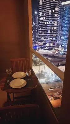 a table in a balcony with a view of a city at Marina View Manchester tower in Dubai
