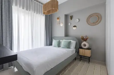 a bedroom with a bed with white sheets and a window at Quiet 1BR with river view in Dubai