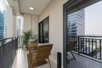 a balcony with two chairs and a table at Quiet 1BR with river view in Dubai