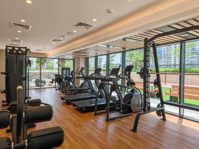 a gym with several treadmills and elliptical machines at Quiet 1BR with river view in Dubai