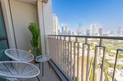 a balcony with two chairs and a view of the city at The Legend Fashionable 2 Bed Apartment in Downtown in Dubai