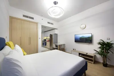 a bedroom with a bed and a tv on the wall at Aura Azizi - Downtown Jabel Ali by Golden Casa in Dubai