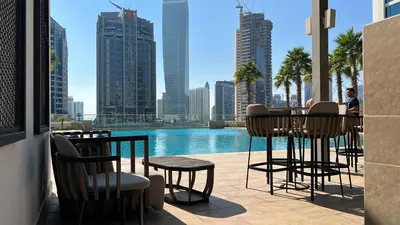 a patio with a view of a pool and buildings at Keyrock Living - Studio with Burj Khalifa View in Dubai