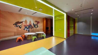 a room with a table and chairs and a mural at Keyrock Living - Studio with Burj Khalifa View in Dubai