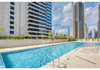 a swimming pool on a building with tall buildings at Keyrock Living - Studio with Burj Khalifa View in Dubai