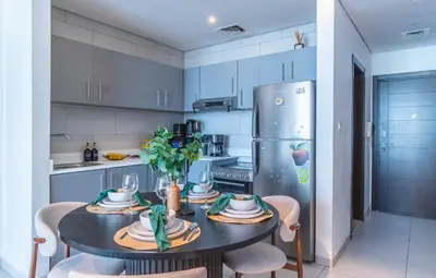 a kitchen with a table with chairs and a refrigerator at Unforgettable Canal & Sea View in Dubai Marina in Dubai