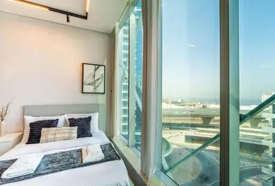 a bedroom with two beds and a large window at Unforgettable Canal & Sea View in Dubai Marina in Dubai