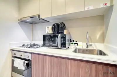 a kitchen with a sink and a microwave at Hot Offer Modern 1BR with Scenic Water Canal Views by Deluxe Holiday Homes in Dubai