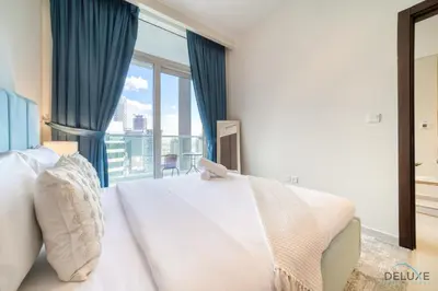 a bedroom with a bed and a large window at Hot Offer Modern 1BR with Scenic Water Canal Views by Deluxe Holiday Homes in Dubai