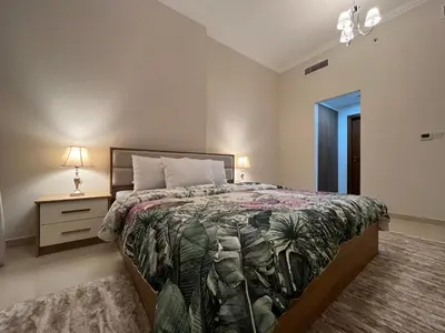 a bedroom with a bed and a night stand with a lamp at 3 Minutes to Dubai Mall! DVR Vacation Homes in Dubai
