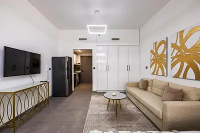 a living room with a couch and a tv at V2 tower Sports city I Studio in Dubai