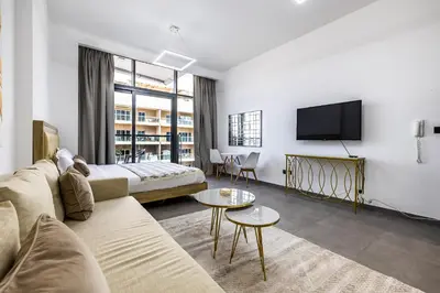 a living room with a couch and a tv at V2 tower Sports city I Studio in Dubai