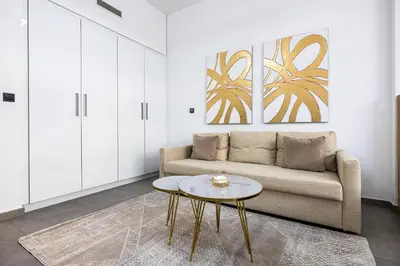 a living room with a couch and a table at V2 tower Sports city I Studio in Dubai