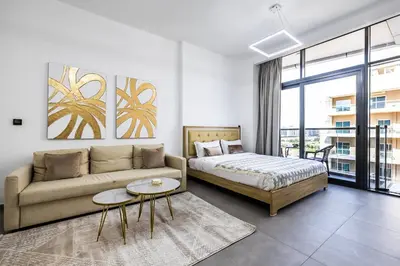a living room with a couch and a bed at V2 tower Sports city I Studio in Dubai