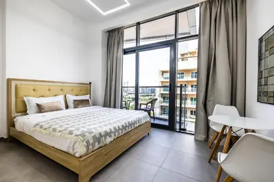 a bedroom with a bed and a large window at V2 tower Sports city I Studio in Dubai