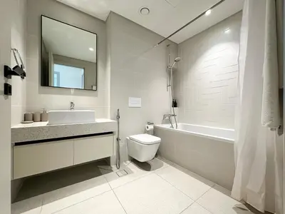 a bathroom with a sink and a toilet and a bath tub at Trophy - Marina Vista Sea View Suite in Dubai