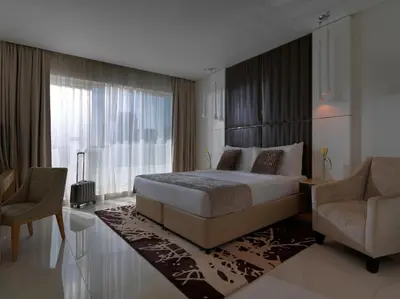 a bedroom with a large bed and two chairs at DAMAC Maison Canal Views in Dubai