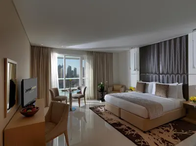 a hotel room with a large bed and a television at DAMAC Maison Canal Views in Dubai