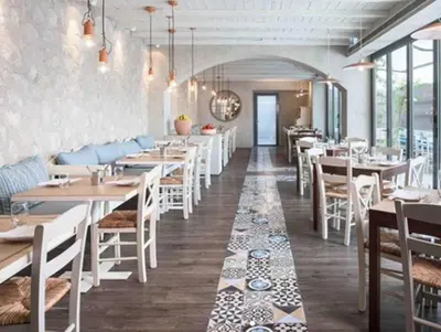 a restaurant with white tables and white chairs at Armada Avenue Hotel in Dubai