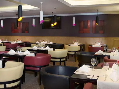 a restaurant dining room with tables and chairs at Armada Avenue Hotel in Dubai