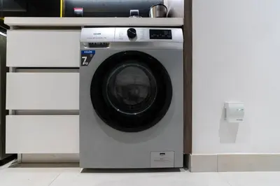 a washing machine is in a white wall at Unique Studio in JVC - Dubai in Dubai