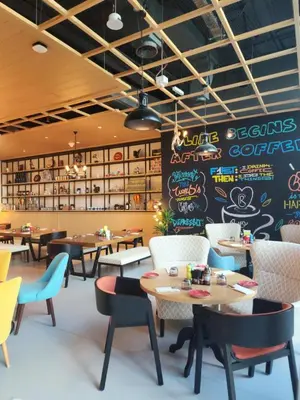 a restaurant with tables and chairs and a chalkboard at Modern 1BR Seven Palm Private Beach Infinity Pool in Dubai