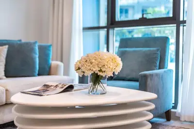 a vase of flowers on a table in a living room at Modern 1BR Seven Palm Private Beach Infinity Pool in Dubai