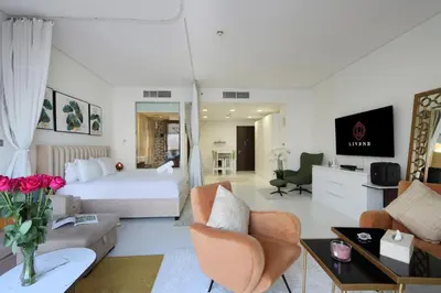 a hotel room with a bed and a living room at Livbnb Seaside Studio in Palm Jumeirah with Private Terrace and Direct Access to Nakheel Mall in Dubai