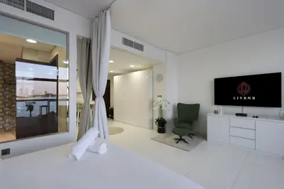 a hotel room with a bed and a flat screen tv at Livbnb Seaside Studio in Palm Jumeirah with Private Terrace and Direct Access to Nakheel Mall in Dubai