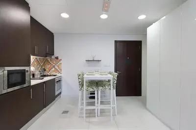 a kitchen with a table and some chairs in it at Livbnb Seaside Studio in Palm Jumeirah with Private Terrace and Direct Access to Nakheel Mall in Dubai