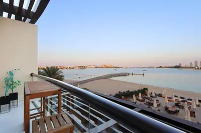a balcony with a view of the beach and water at Livbnb Seaside Studio in Palm Jumeirah with Private Terrace and Direct Access to Nakheel Mall in Dubai