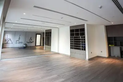 a large room with a wooden floor and a large mirror at Downtown Luxurious 1BR Near Dubai Mall and Fountain in Dubai