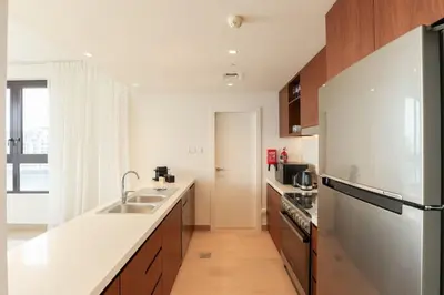 a kitchen with a sink and a refrigerator at HiGuests - Family Dream Escape with Private Beach Access in Dubai